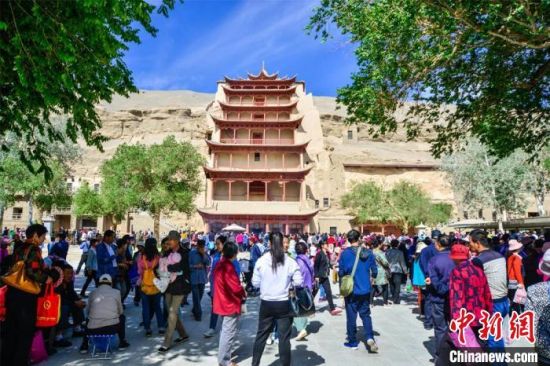 中國農(nóng)歷四月初八，敦煌民眾傳承歷史習(xí)俗，前往莫高窟燒香禮佛、祈福。(資料圖) 王斌銀 攝