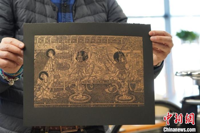 圖為手工書藝人展示敦煌雕版壁畫印刷品?！【琶赖┰?　攝