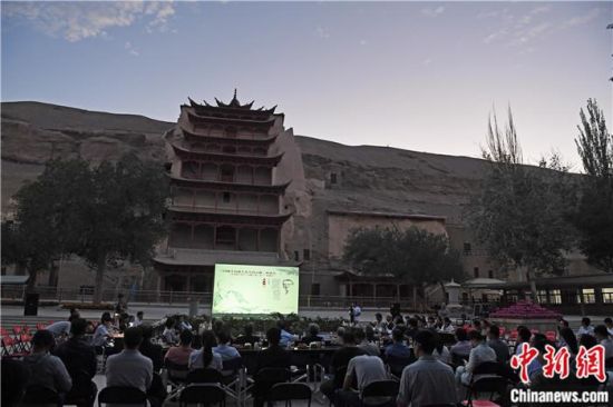 2018年8月，在敦煌莫高窟標(biāo)志性建筑“九層樓”前，《回顧平山郁夫先生的貢獻(xiàn)》座談會(huì)舉行。來(lái)自中日兩國(guó)的專家、學(xué)者共同懷念這位情系敦煌數(shù)十載的繪畫(huà)巨匠、中日友好的文化使者、世界文化遺產(chǎn)的守護(hù)者。中新社記者 楊艷敏 攝