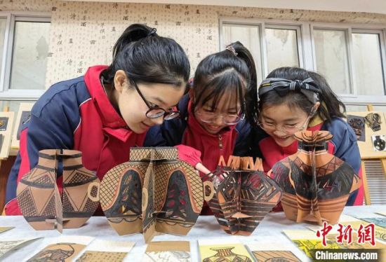 圖為學(xué)生用紙創(chuàng)作的立體彩陶?！⒂裉?攝