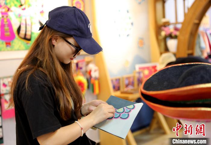 圖為民眾體驗國家級非遺項目盤繡技藝?！⊙Φ?攝