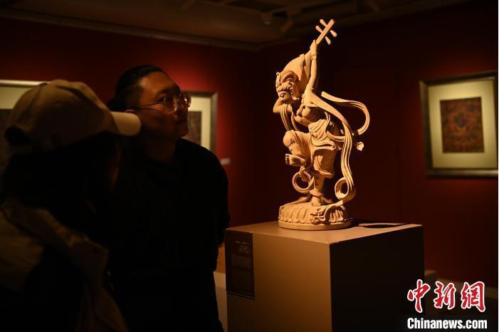 圖為季茂杰向參觀者介紹自己創(chuàng)作敦煌木雕的過程。李亞龍 攝</p>
<p>