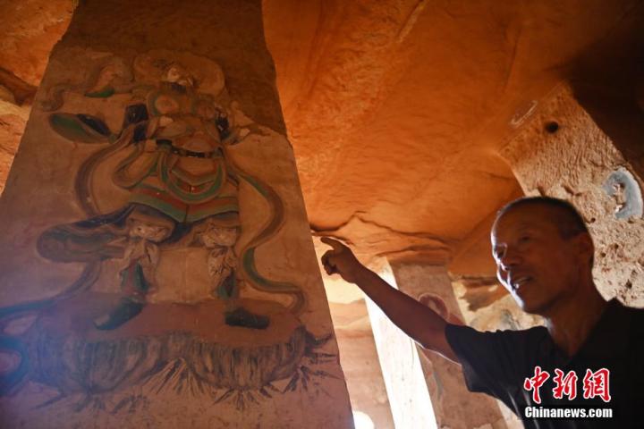7月15日，甘肅省平?jīng)鍪袥艽h百里石窟長廊羅漢洞石窟內(nèi)，該窟文保員郭建平介紹窟內(nèi)石刻彩繪壁畫。郭建平家中三代人曾自發(fā)保護(hù)羅漢洞石窟。羅漢洞石窟遺存40余個窟龕，以北魏至清代風(fēng)格為主。中新社記者 李亞龍 攝</p>
<p>