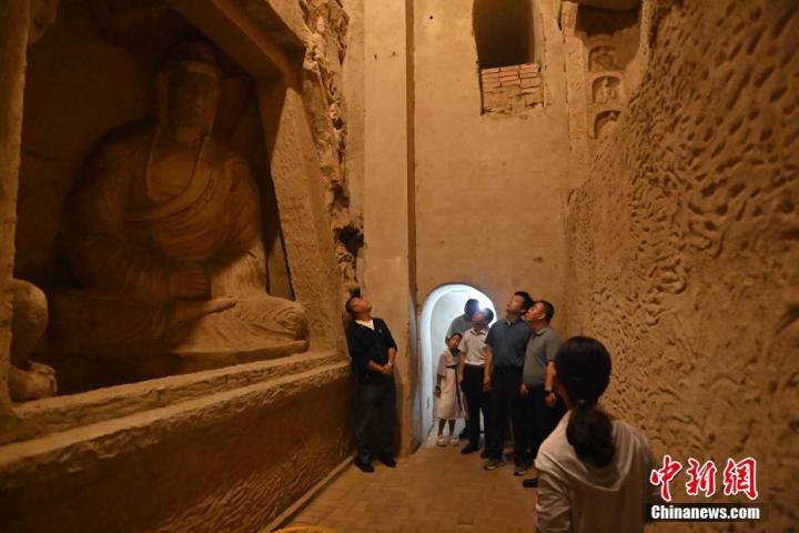 7月15日，游人參觀甘肅省平?jīng)鍪袥艽h百里石窟長廊中的王母宮石窟。百里石窟長廊位于涇川縣境內(nèi)，由512個石窟、5眼窟中石井組成，現(xiàn)存王母宮石窟、鳳凰山石窟、南石窟寺、丈八寺石窟、羅漢洞石窟、太山寺石窟等規(guī)模較大的石窟群，還有數(shù)量眾多的小石窟群。王母宮石窟又名千佛洞，該窟設(shè)計(jì)宏大，造像生動，窟內(nèi)擁有造像數(shù)百尊，是較為珍貴的佛教文化歷史遺存。中新社記者 李亞龍 攝</p>
<p>